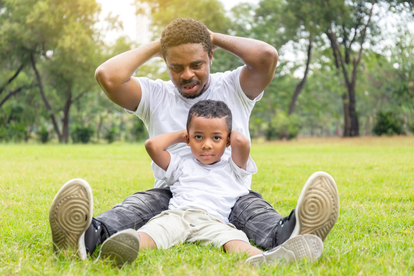 Cheerful african american father and son playing exercising in the park, Happiness family concepts